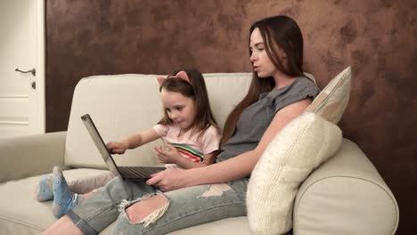 Little-girl-shows-something-to-her-mother-on-the-laptop