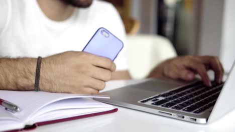 Hombre-de-negocios-trabajando-en-ordenador-portátil-y-usar-teléfono-móvil