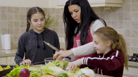Little-girls-help-mother-to-cook-salad-for-dinner