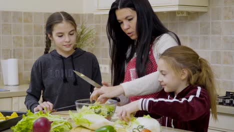 Niñas-ayudar-a-madre-a-cocinar-ensalada-para-la-cena