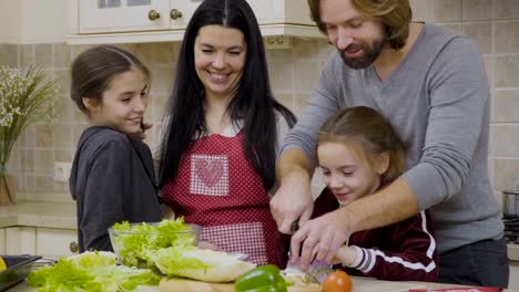 Father-and-daughter-cuts-the-onion-for-salad