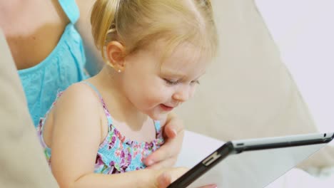 Girl-playing-touch-screen-game-on-tablet-indoor