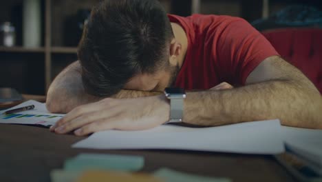 Tired-business-man-lying-on-papers-at-table.-Businessman-sleeping-on-desk