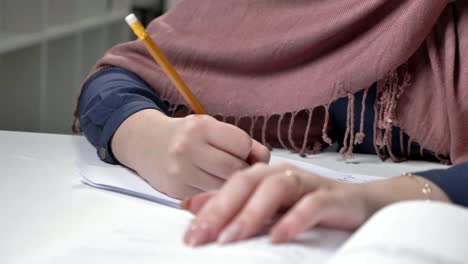 Beautiful-female-hands-write-in-a-notebook.-Pencil.-Manicure.-Close-up.-Arab-women-in-the-office-60-fps