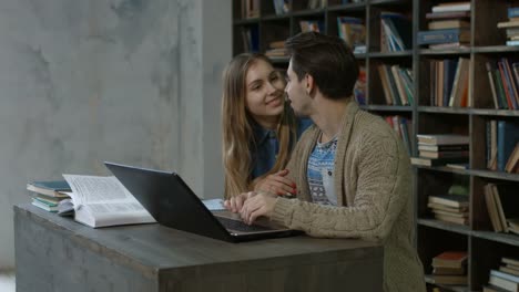 Happy-students-with-laptop-networking-in-library