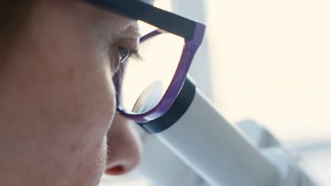 Female-scientist-looking-through-microscope