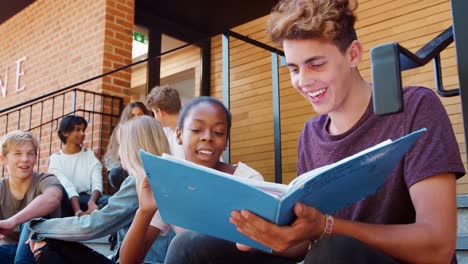 Group-Of-Teenage-Students-Sitting-On-Steps-Of-College-Building