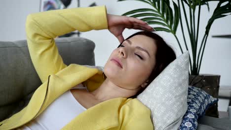 Headache,-Tense-Woman-Laying-on-Sofa-at-Home