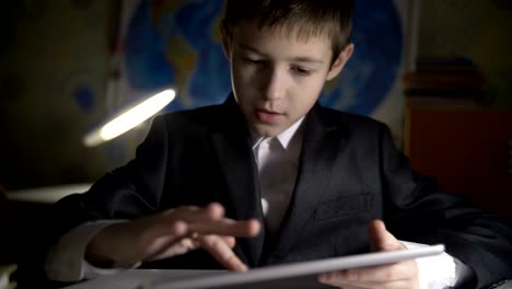 boy-doing-homework-at-home-using-tablet,-found-key-how-to-solve-the-lessons