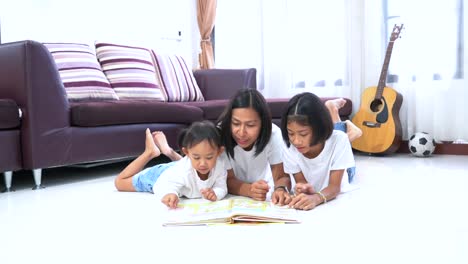 Mother-and-daughter-read-a-book-are-lying-on-a-floor-at-home