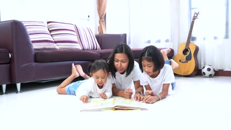 Madre-e-hija-que-leer-un-libro-yacen-en-una-planta-en-casa