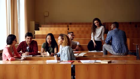 Young-people-are-talking-and-relaxing-during-break-between-university-lectures,-students-are-enjoying-rest-and-communication.-Modern-lifestyle-and-education-concept.