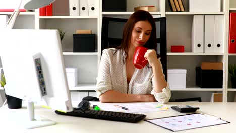 businesswoman-with-cup-working-in-office