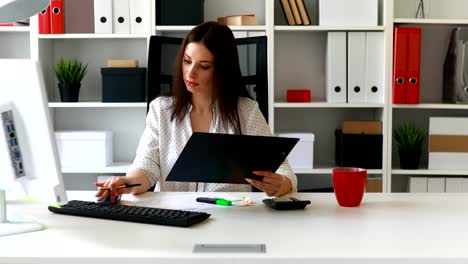 businesswoman-working-at-computer-in-light-office