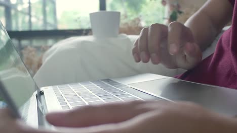 Young-asian-woman-doing-research-work-for-her-business.-Smiling-woman-sitting-on-sofa-relaxing-while-browsing-online-shopping-website.-Happy-girl-browsing-through-internet-during-free-time-at-home.