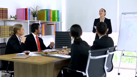 Chica-del-negocio-explicando-acerca-de-su-proyecto-y-todos-en-la-sala-de-reuniones-de-acuerdo-le.