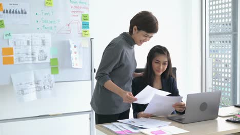 Administradores-asiáticos-hablando-mujer-tarea-logro-al-empleado.-Mujer-de-negocios-feliz-y-sonriente.-concepto-de-éxito-de-la-gestión-empresarial,-buen-trabajo-y-logros.