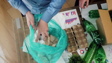 Man-in-office-putting-paper-waste-in-recycling-bag