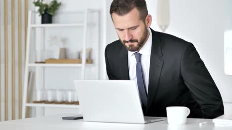 Geschäftsmann-kommen-Büro--und-Eröffnung-Notebook-bei-der-Arbeit