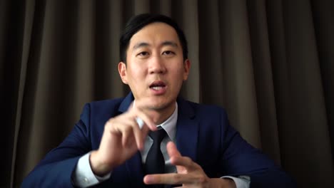 Young-Asian-business-man-speaking-on-the-video-call-conference-with-serious-look