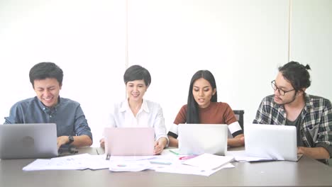 Reunión-de-negocios.-Pequeño-en-marcha-reunión-de-negocios-en-la-habitación.-Equipo-asiático-con-hombre-y-mujer-terminar-su-trabajo-y-celebrando,-sentado,-frente-a-cámara.-Nuevo-modelo-de-negocio-en-marcha-conceptos.