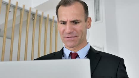 Frustrated-Angry-Middle-Aged-Businessman-Working-on-Laptop