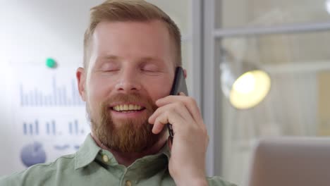 Happy-Businessman-Speaking-on-Phone-at-Work