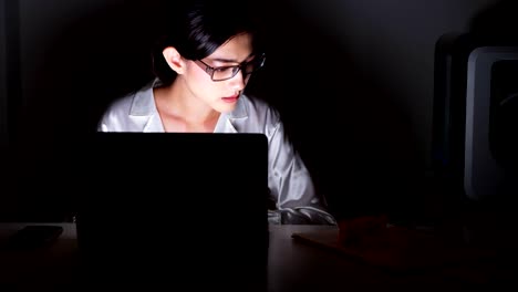 Beautiful-asian-woman-working-on-her-computer-with-3d-printer-and-model-in-background,-full-concentration.-Modern-start-up-global-business-concept.