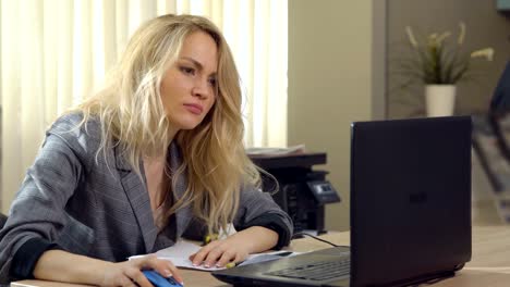 angry-business-woman-in-suit-works-at-the-computer-in-office.