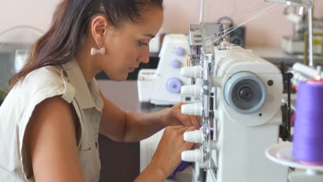 Tela-de-costura-de-mujer-en-la-máquina-de-coser