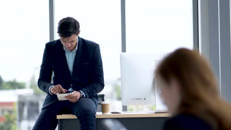 Geschäftsmann-sucht-mit-einem-Tablet-im-Büro