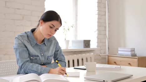 Young-Girl-Reading-Book-and-Writing-on-Paper,-Contract