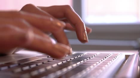 Female-is-Writing-and-Working-on-a-Laptop