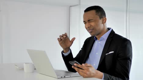 Frustrated-Casual-Afro-American-Businessman-Reacting-to-Loss-while-Using-Smartphone