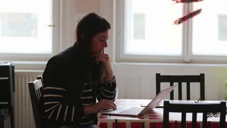 Candid-4K-clip-of-woman-browsing-internet-on-her-laptop-from-home