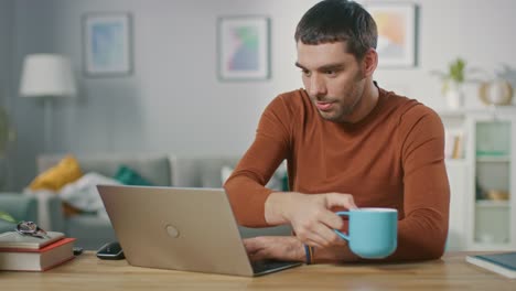 Retrato-de-sonriente-guapo-trabajando-en-ordenador-portátil,-sentado-en-su-escritorio-de-madera-en-casa.-Hombre-navegando-por-Internet,-trabajando-en-la-Notebook-de-su-sala-de-estar.