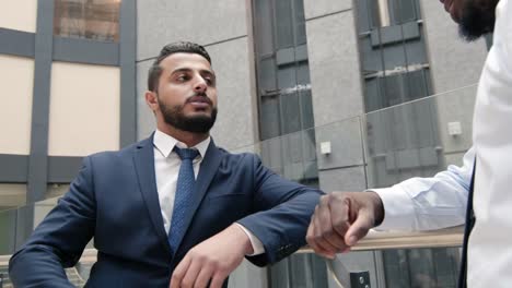 Arabian-businessman-shaking-hands-with-colleague-indoor