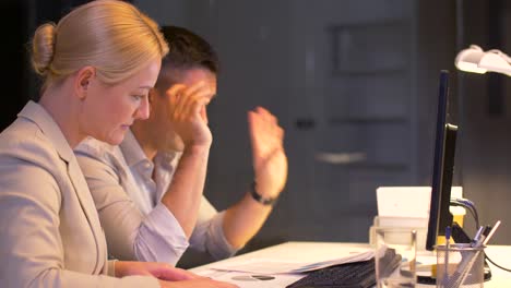 equipo-de-negocio-con-documentos-trabajando-tarde-en-la-oficina