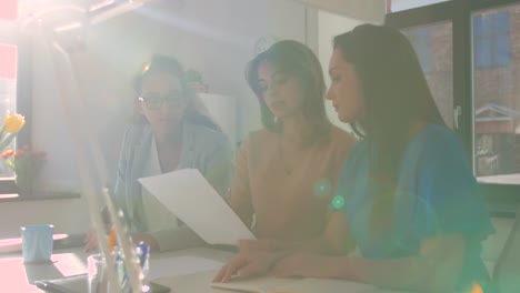 businesswomen-discussing-papers-at-office