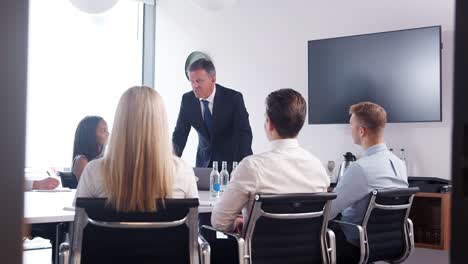 Reifen-Sie-Geschäftsmann-Adressierung-Fraktionssitzung-Tisch-am-Graduate-Recruitment-Assessment-Tag