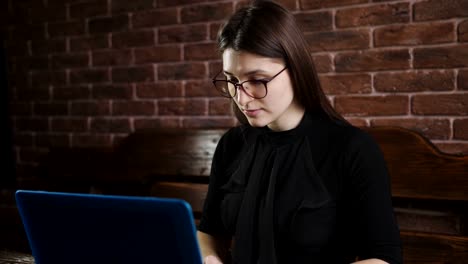 Portrait-of-a-young-girl-working-behind-the-notebook.-Beautiful-woman-typing-text-on-laptop-keyboard.