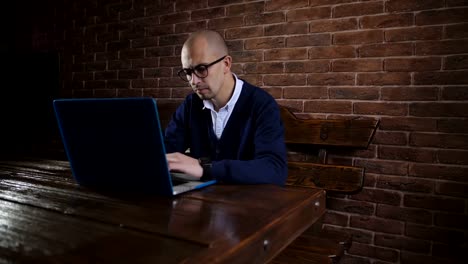 Business-man-with-glasses-is-typing-text-on-laptop-keyboard.-The-work-of-a-freelancer.