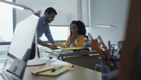 Mujer-de-negocios-hablando-con-celular-y-compañero-de-trabajo-en-oficina