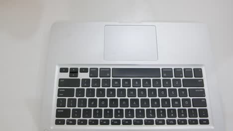 Top-view-of-Indian-male-hands-typing-on-a-keyboard-of-a-computer-side-view-as-he-withdraws-his-hands