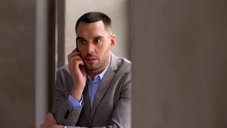 businessman-calling-on-smartphone-at-office