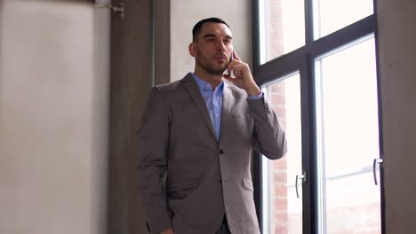 businessman-calling-on-smartphone-at-office