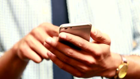 Close-up-view-of-casual-businessman-using-smartphone