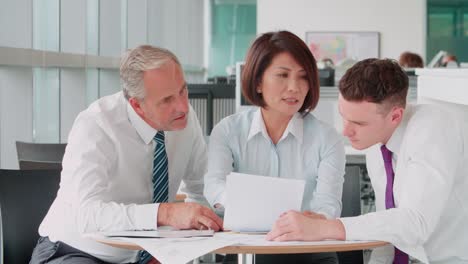 Three-corporate-colleagues-meeting-in-an-office