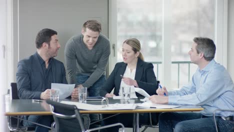 Group-of-businesspeople-discussing-important-documents-at-businessmeeting