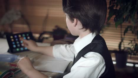 4K-Hi-Tech-Shot-of-a-Child-Doing-Homework-and-Searching-Tablet